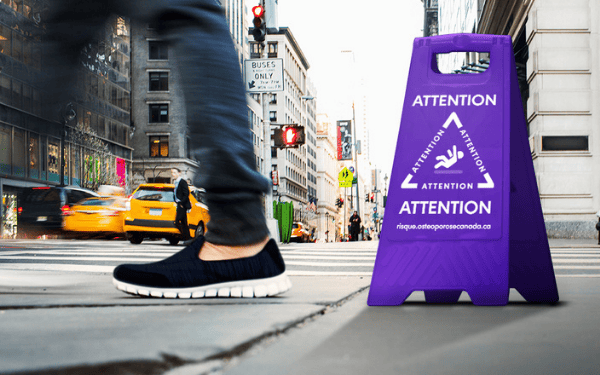 Gros plan du pied d'une personne passant devant un panneau de mise en garde