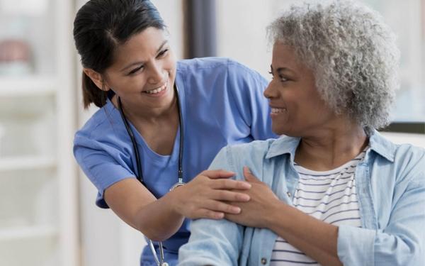Professionnelle de la santé tenant la main d'une femme âgée