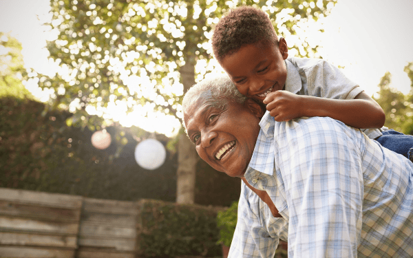 Grandson on his grandfathers back smiling