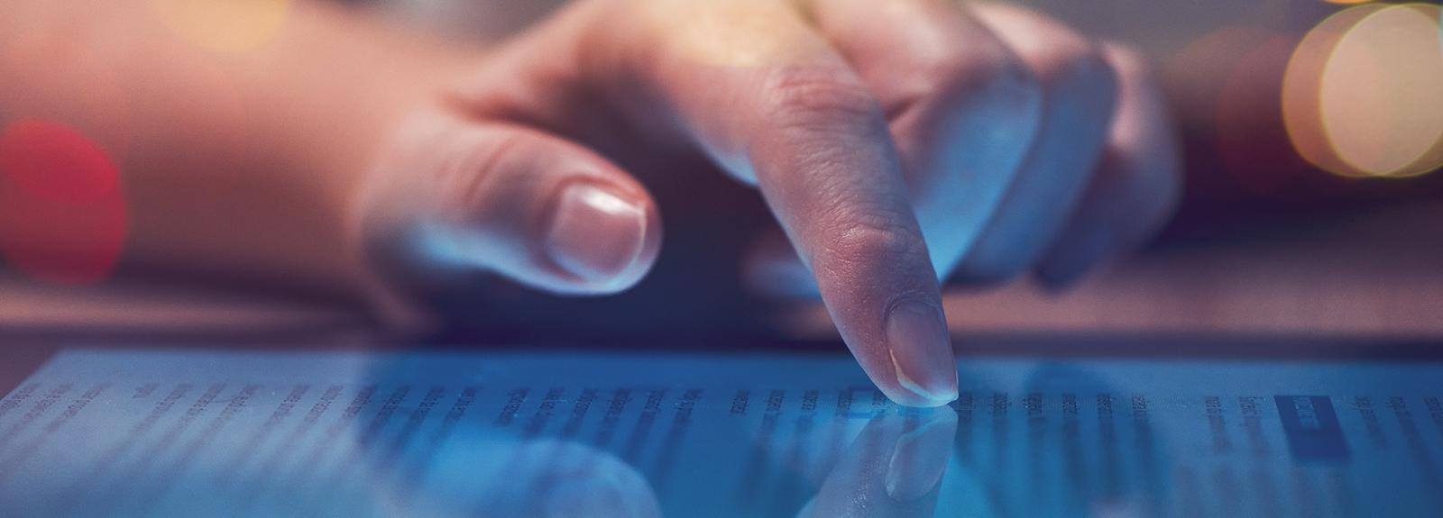 Gros plan d'un doigt faisant défiler l'écran d'une tablette