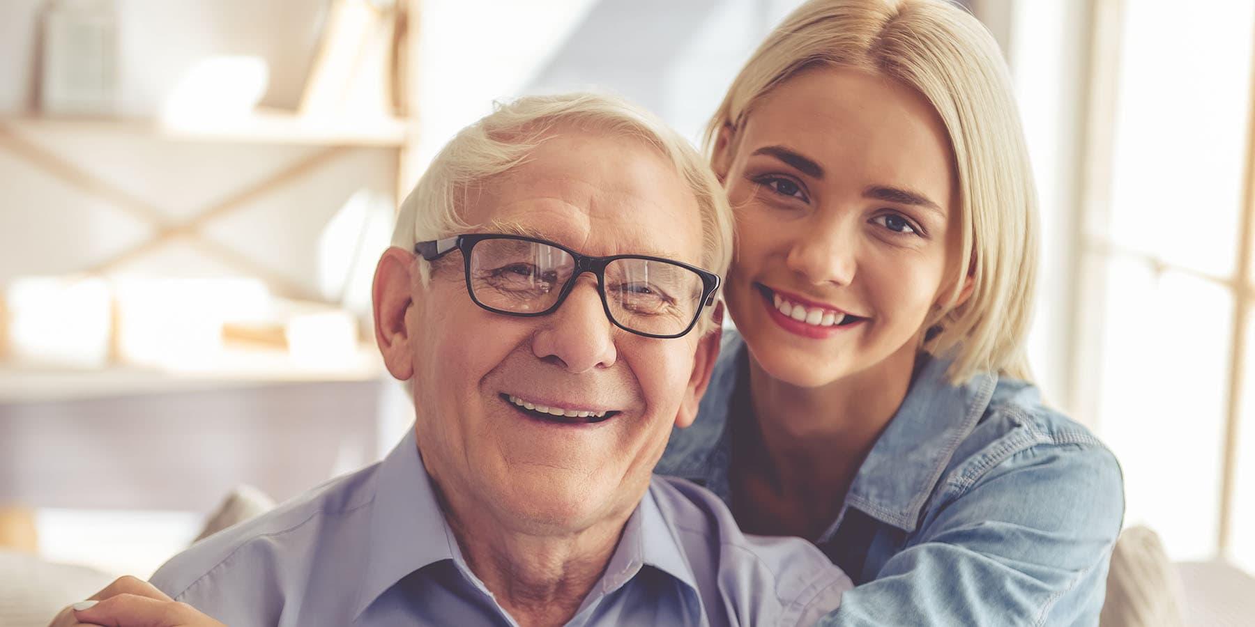 Jeune femme et homme âgé posant tout sourire