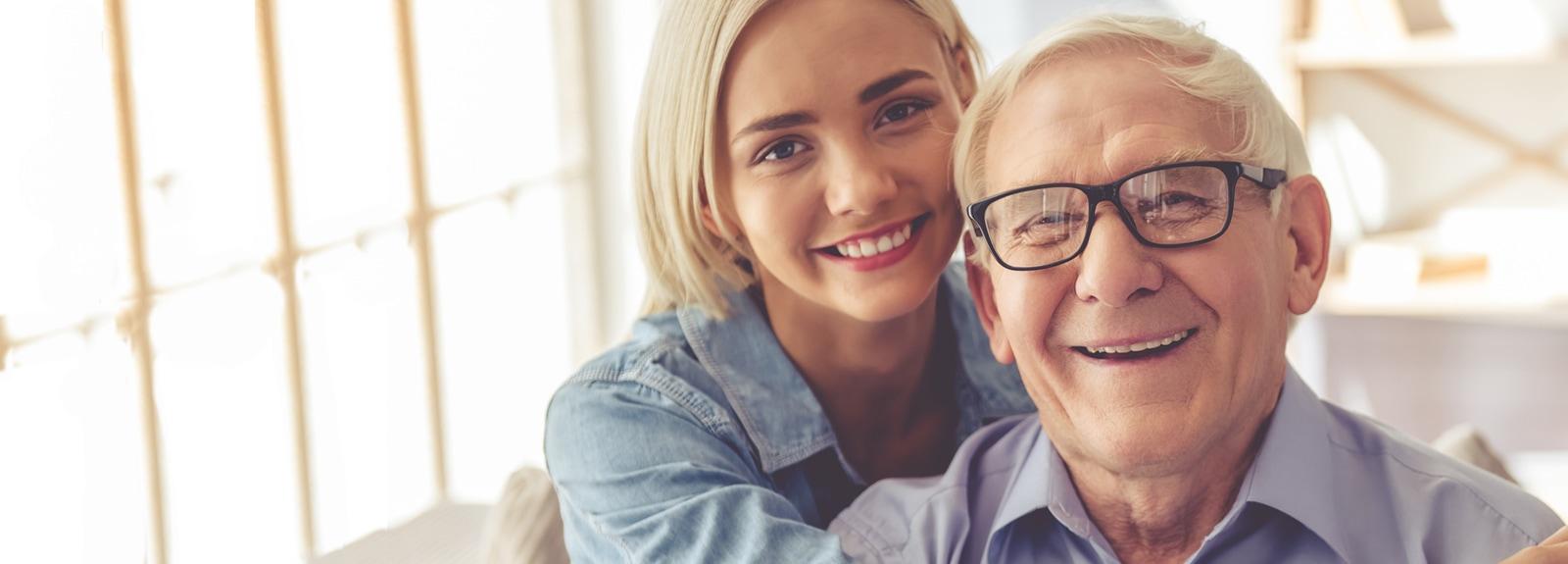 Jeune femme et homme âgé posant tout sourire