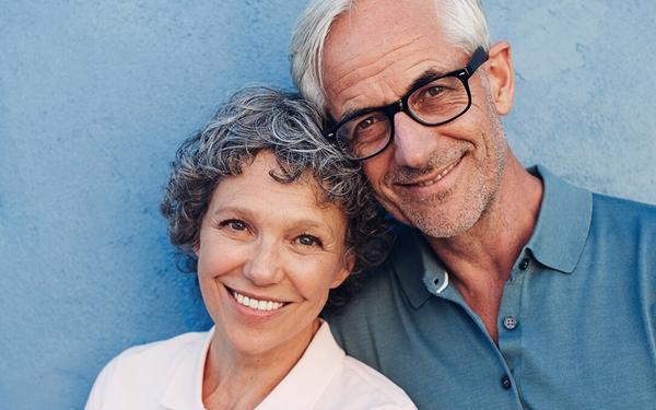 Portrait d'une femme et d'un homme âgés devant un mur bleu