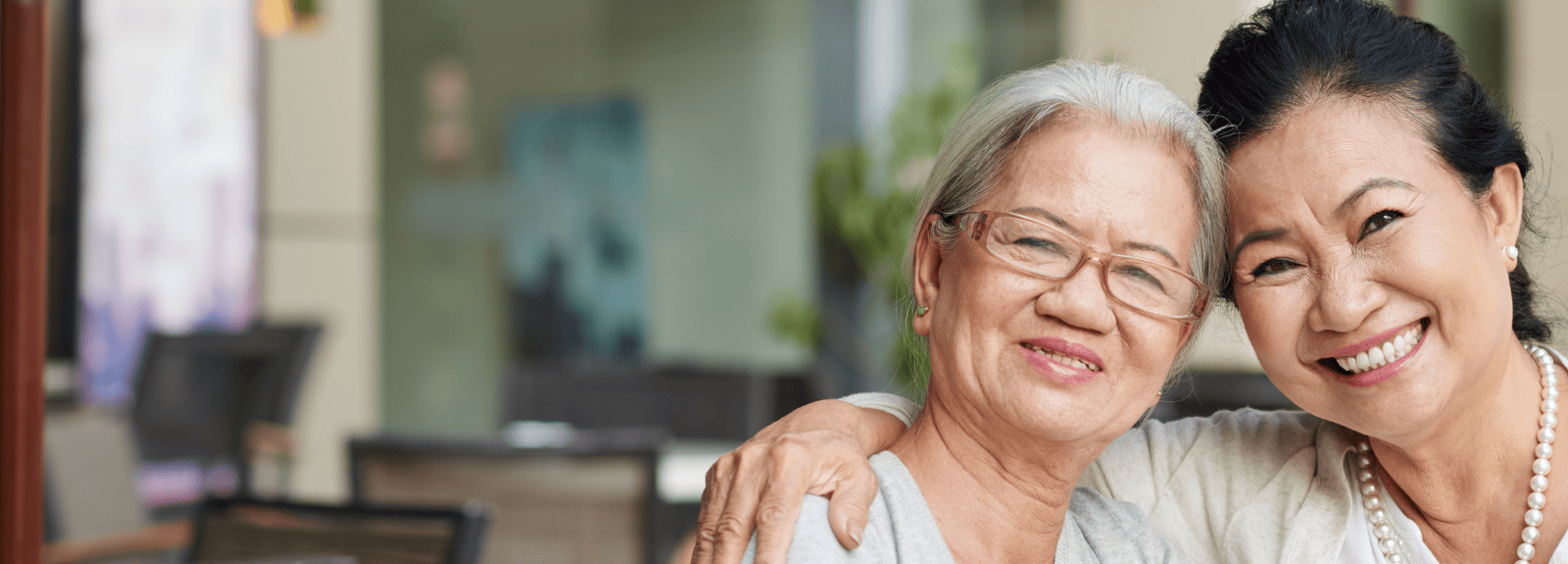 Femme âgée aux côtés d'une autre femme tout sourire