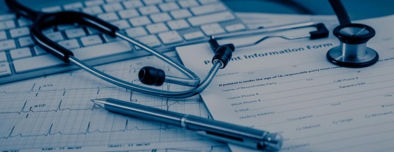 Gros plan bleuté d'un stéthoscope, d'un clavier et d'un stylo sur des formulaires médicaux